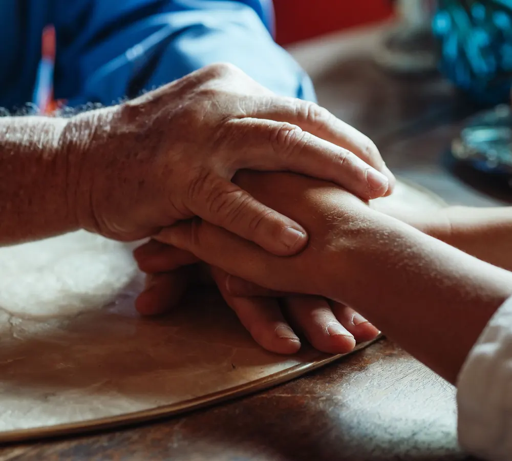 Una mano mayor sosteniendo la mano de una persona más joven