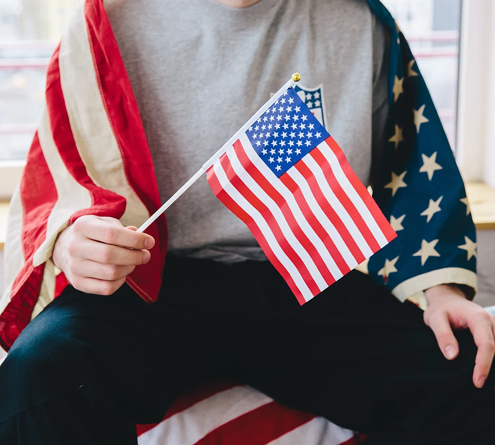 Una persona sosteniendo una banderita de Estados Unidos
