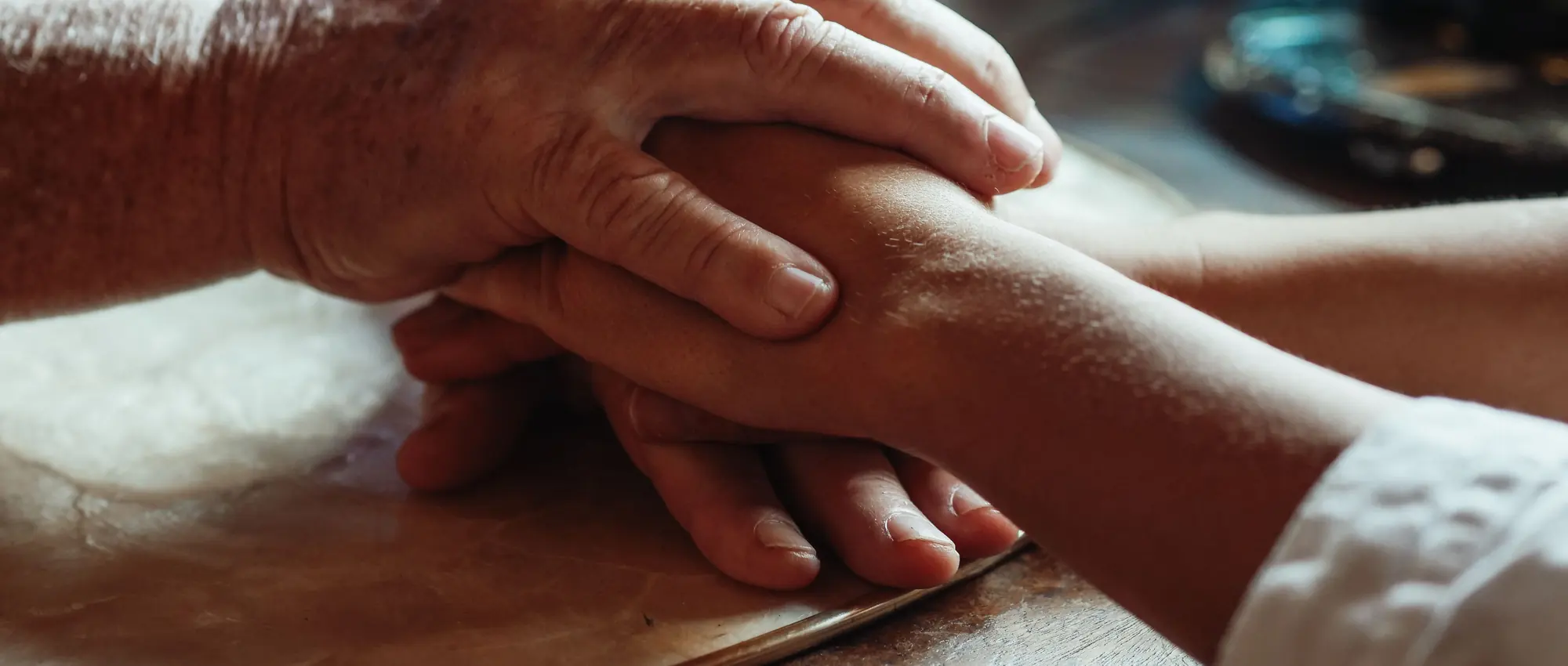 Una mano mayor sosteniendo la mano de una persona más joven